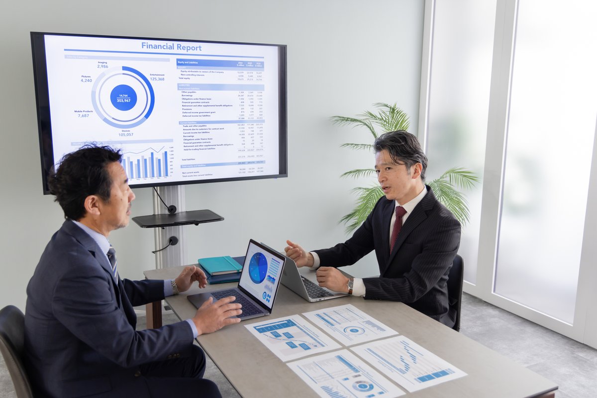 モニターの前で打ち合わせするビジネスパーソン