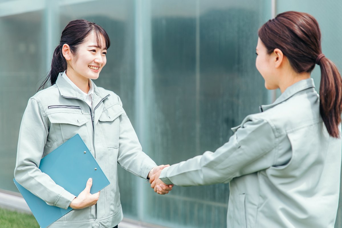 握手する作業着姿の女性会社員（建設）