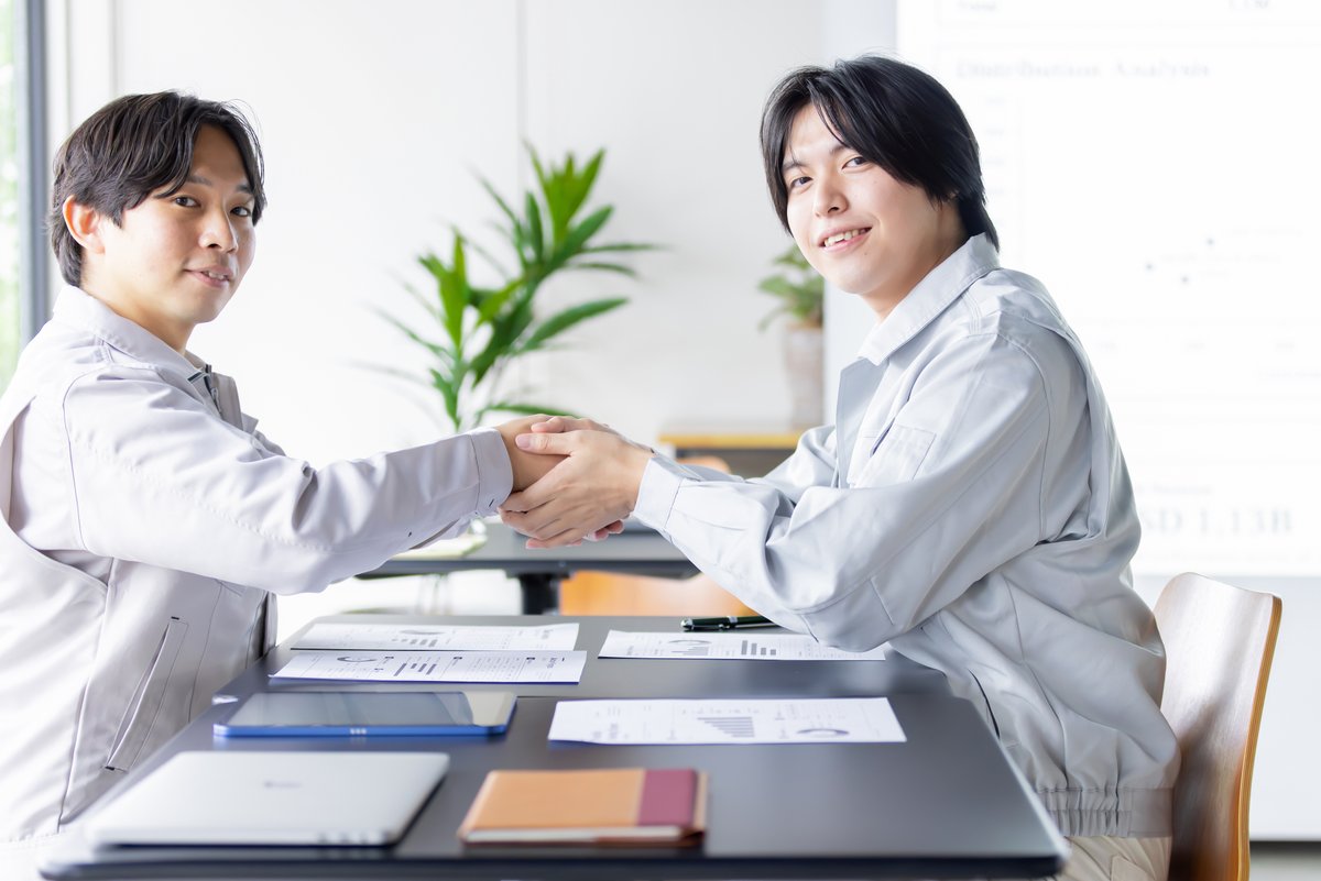 握手を交わして笑顔を見せる男性作業員